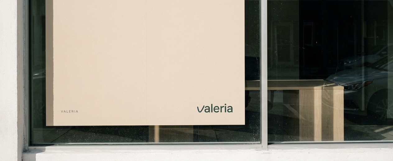 Un cartel de VALERIA en el escaparate de un local de Miami, el logotipo sobre arena